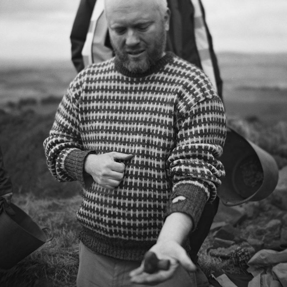 An archaeologist with a hand out to show an archaeological find