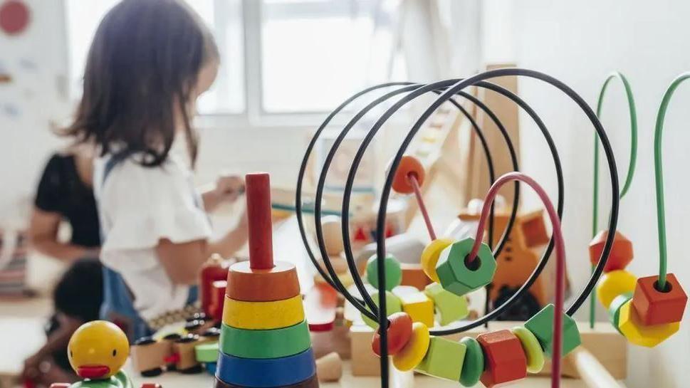 Child playing in a nursery with toys in foreground