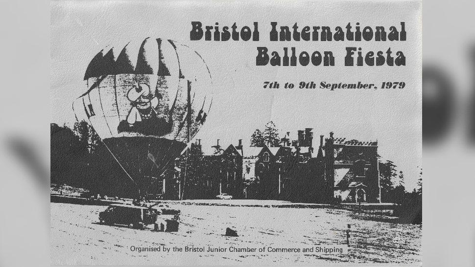 A black and white picture of  a hot air balloon on one side, row of houses in the background and the text reading Bristol International Balloon Fiesta., 7th to 9th September 1979.