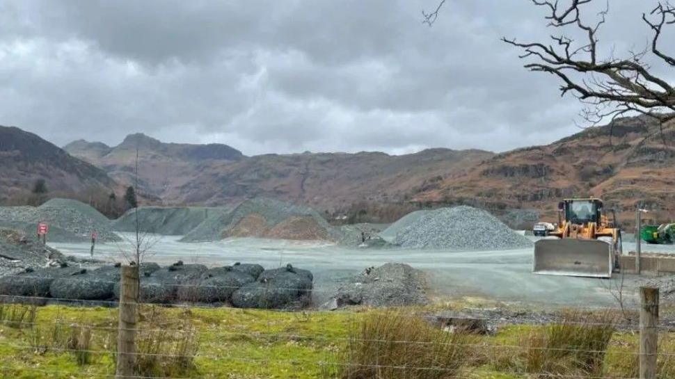 A fence with Elterwater quarry in the background