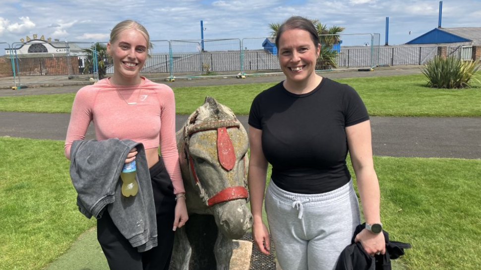 Ava and Andrea next to statue of Dudley the donkey