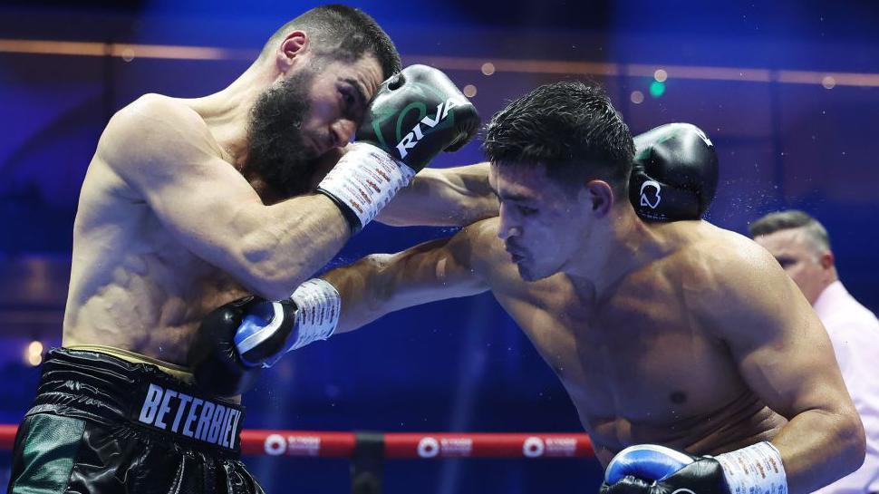 Artur Beterbiev covers up from a Dmitry Bivol punch