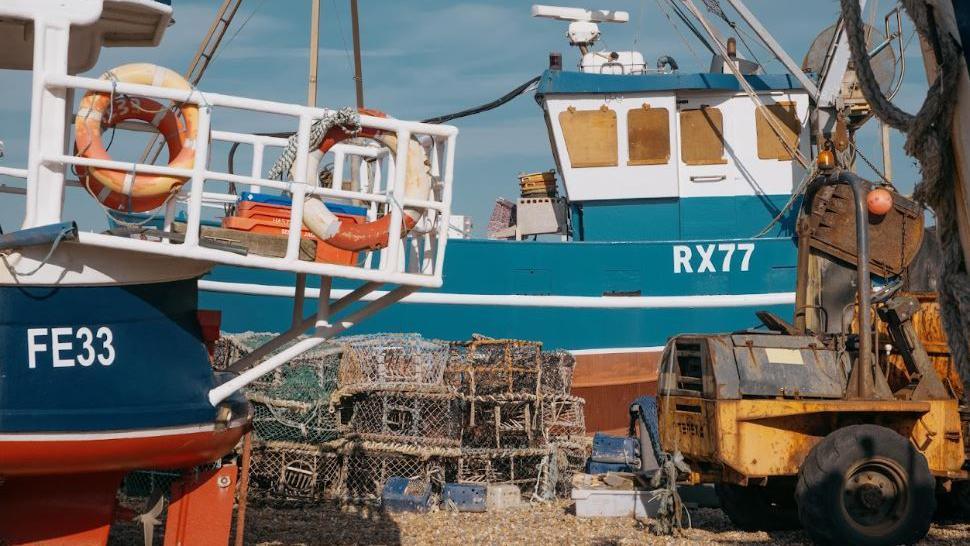 Close up shot of a blue fishing boat with nets on Hastings beach