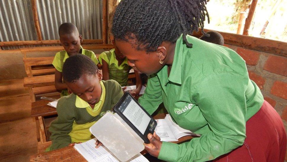 A teacher interacts with a student at a Bridge International school