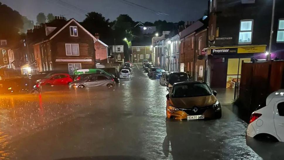 A night-time shot of a street in Dover flooded with lots of cars stuck