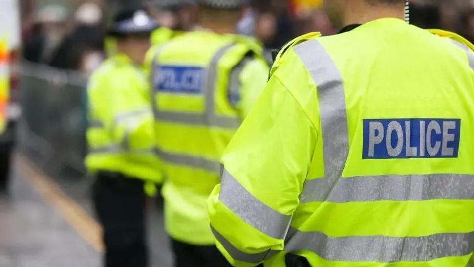 Three police officers wearing high-vis jackets.