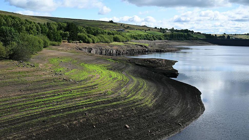 The banks of Baitings Reservoir, near Ripponden, partially revealed by falling water levels