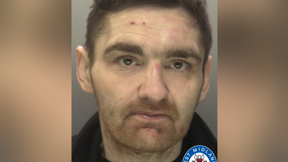 Mugshot of a man with brown hair, in front of a grey background, with part of the West Midlands Police logo in the bottom corner of the picture