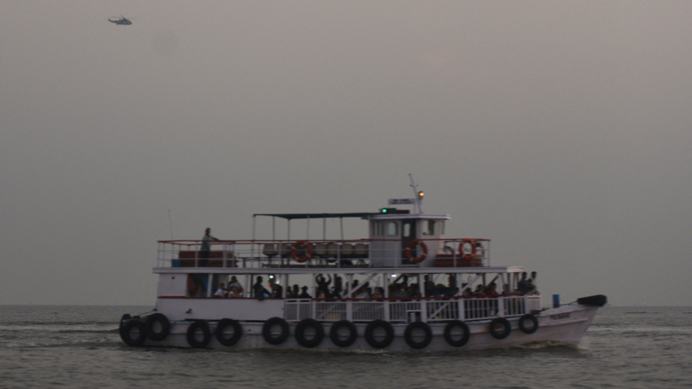 A military helicopter flies over a ferry during a rescue operation after a passenger boat capsized off the coast of Mumbai, India, on 18 December 2024