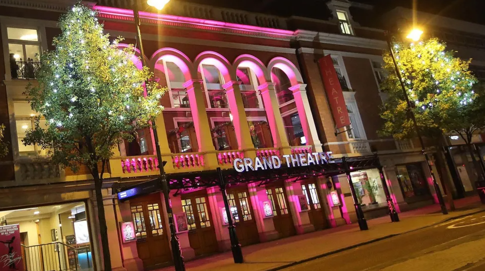 The Grand Theatre at night with pink lighting outside the front of the building