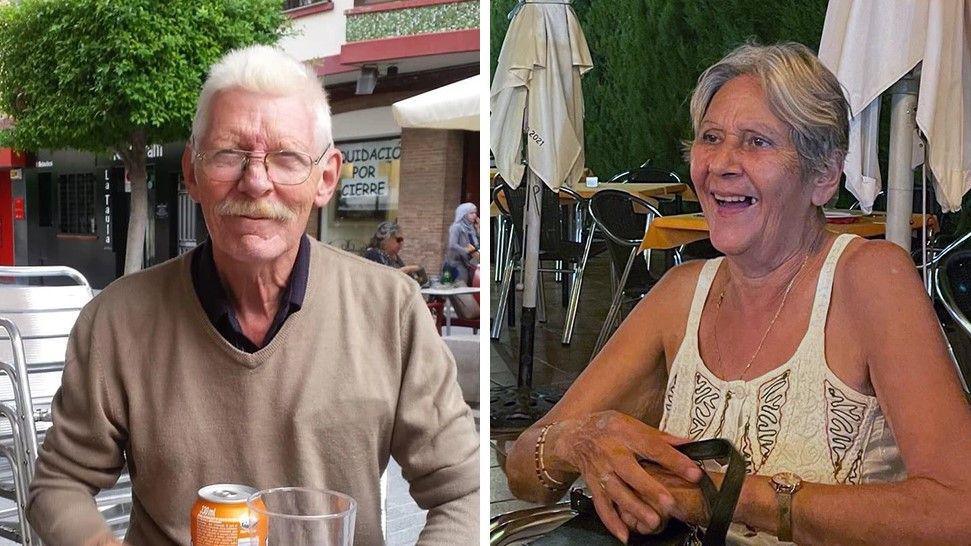 Terri (right) is wearing a white vest top and smiling with a bag on her lap. She has short, grey hair, or her hair is possibly tied back. Don is wearing glasses and has a moustache and is wearing a light brown jumper.