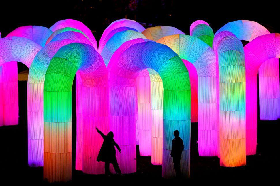 Silhouettes of two people amid brightly-coloured tubes - pinks and blues and oranges and greens.