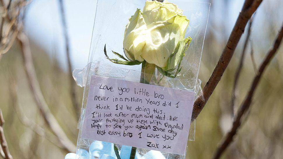 A white rose with a message saying 'Love you little bro'