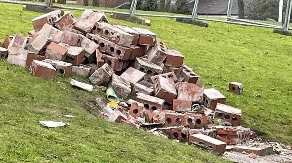 A pile of bricks which were formerly the Josiah Wedgwood statue, lay across a grass verge behind construction fencing.