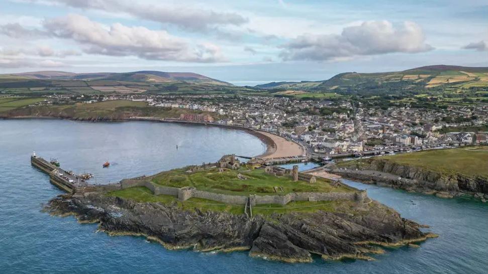 Aerial view of Peel from our at sea with St Patrick's Isle, which features Peel Castle, in the fore.