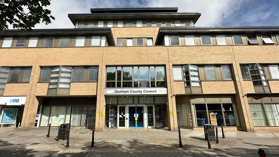 Crook Coroner's Court is a multi-storey light brown-coloured building. A silver sign on the front reads: "Durham County Council".