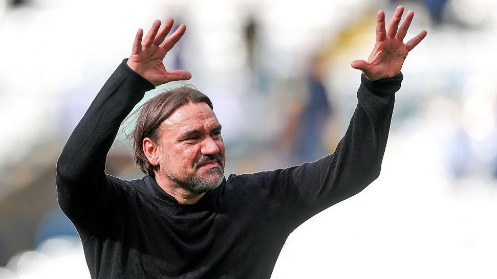 Daniel Farke with his arms in the air acknowledging the fans