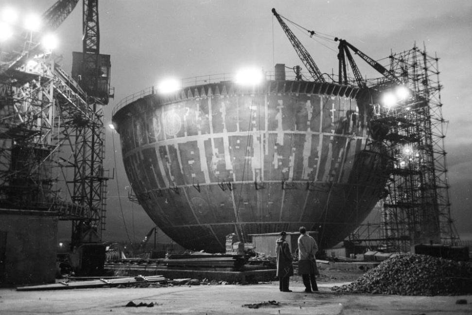 Two men look up at the partially constructed Dounreay dome