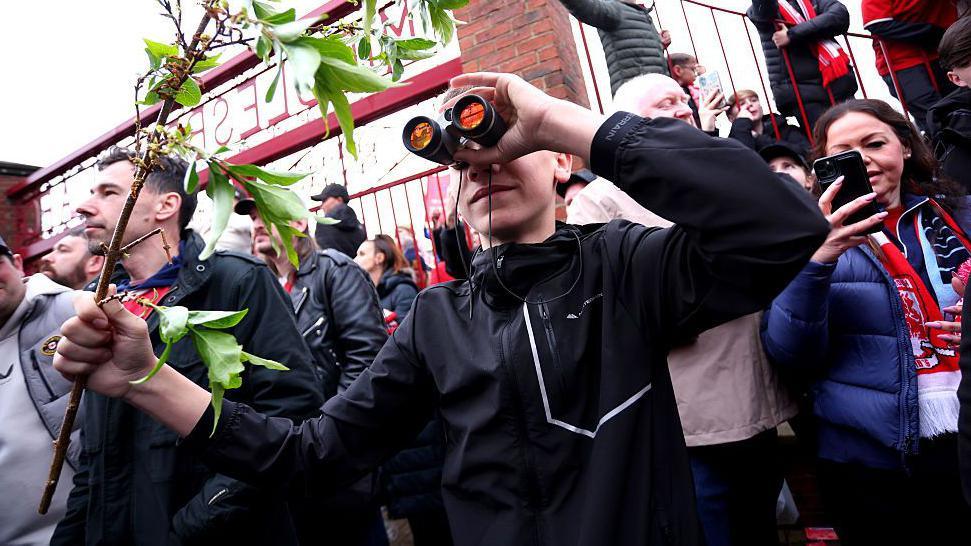 A fan is seen using binoculars outside the stadium prior to the Championship play-off semi-final match between Middlesbrough and Southampton at Riverside Stadium