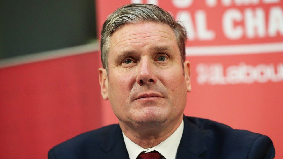 Sir Keir Starmer in front of a red Labour backdrop 