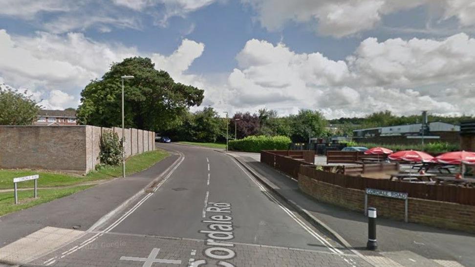 Junction into Cordale Road, Basingstoke - a pub garden can be seen on the right and houses behind a wall on the left.