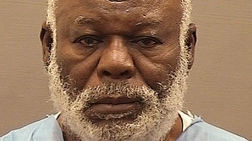 Mugshot of Abu Agile Masud, whohas a white beard and is looking directly at the camera