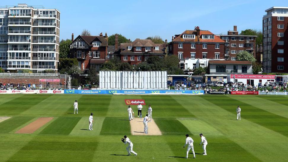 Cricket players on the pitch at Hove