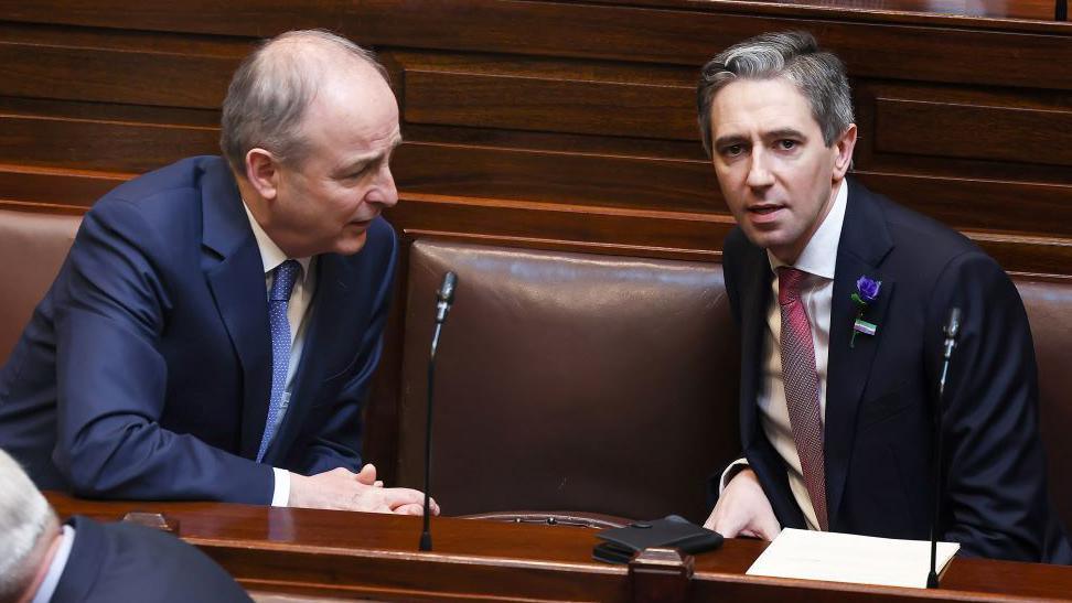 Micheál Martin sits in the Dail in conversation with Simon Harris 