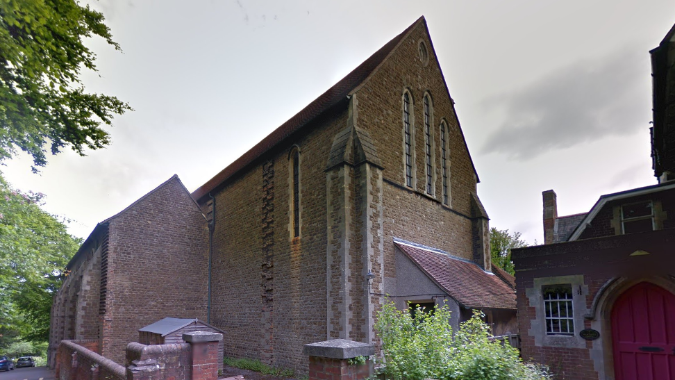 Outside of St Joseph's Catholic Church in Dorking. A brown brick Victorian church with high windows, typical of the period.