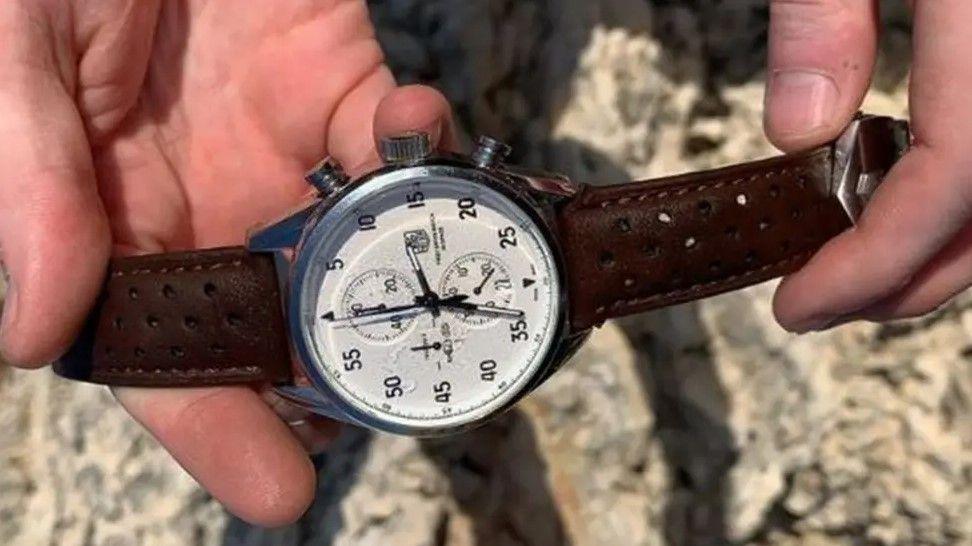 A watch with a brown leather strap belonging to Ben Garland that was found during the search. It has a white face with black watch hands and numbers