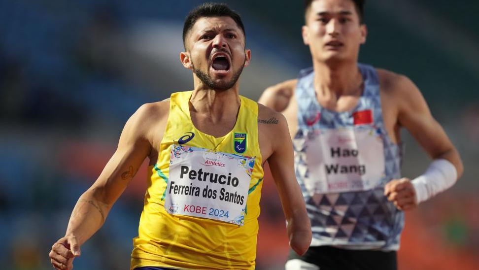 Petrucio Ferreira roars in celebration as he crosses the line to win the T47 100m world title in Kobe in May