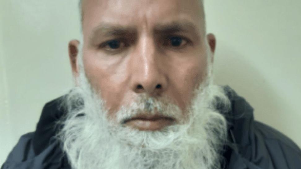 Munawar Hussain in his police mugshot after his arrest