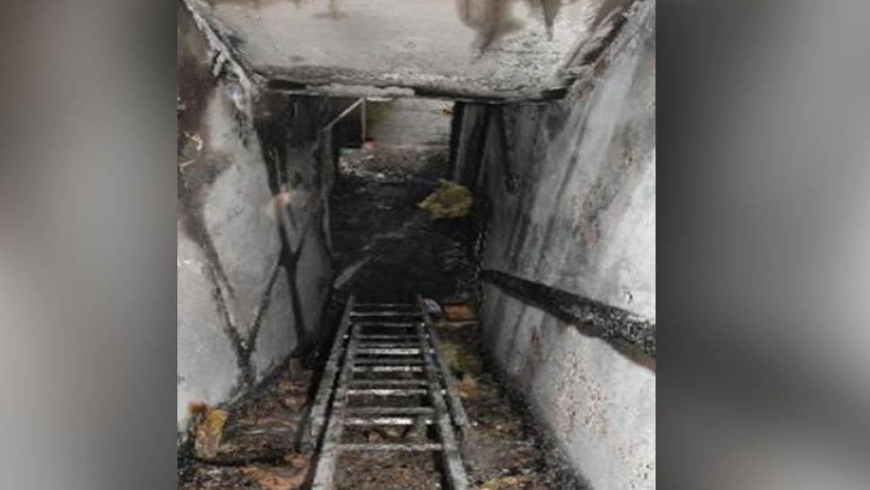 Image taken from inside a home gutted by fire. It shows the view from the top of the first-floor looking down the stairs. 