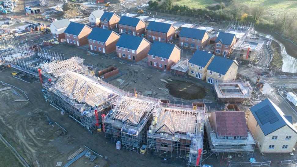 A aerial view of new houses being constructed on what was previously agricultural land in England