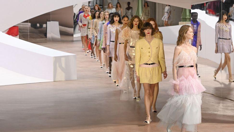 Models walk in line on the Chanel runway in pastel colours