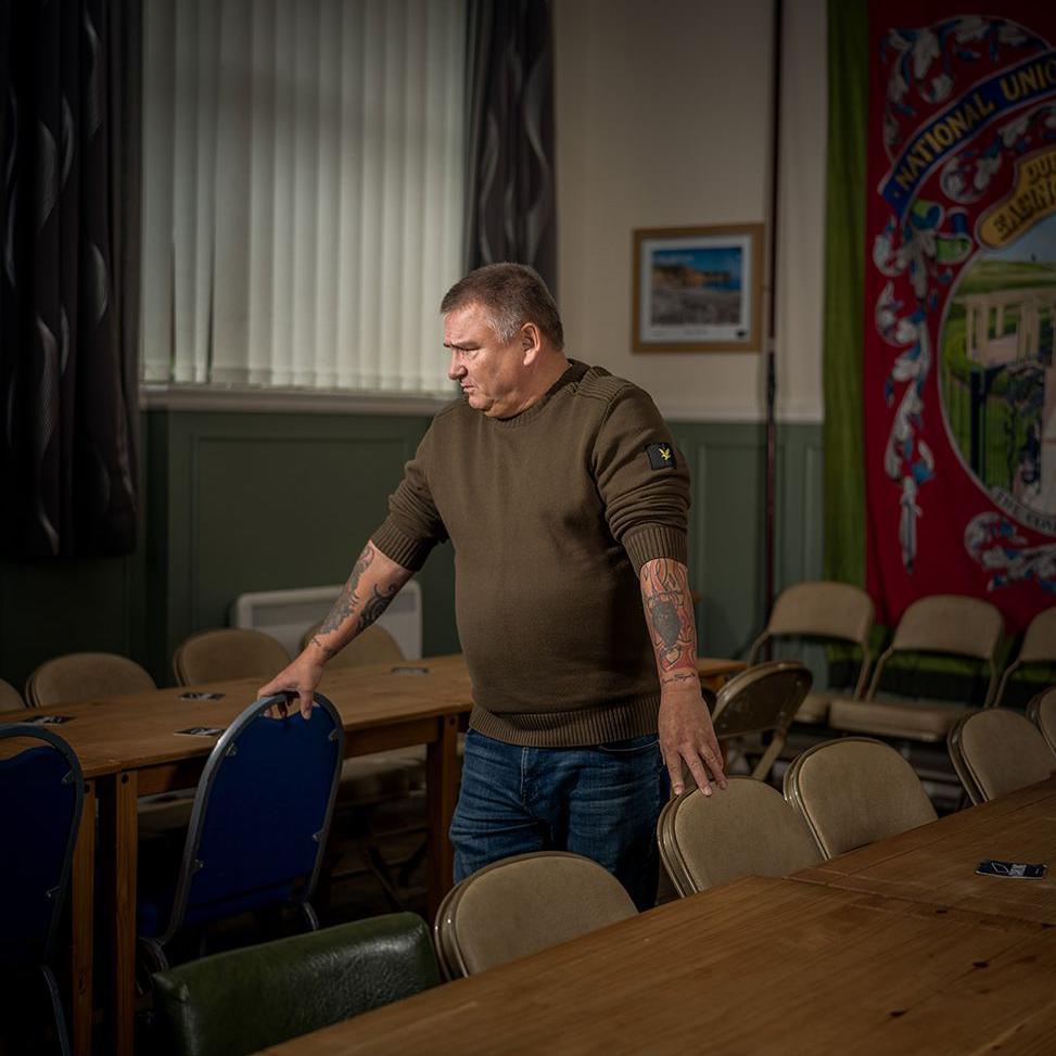 Former miner Steve Ferguse standing by chairs in a social club