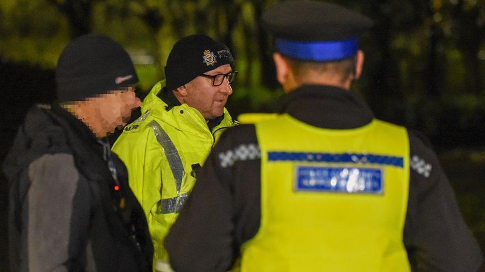 Man standing with two police officers