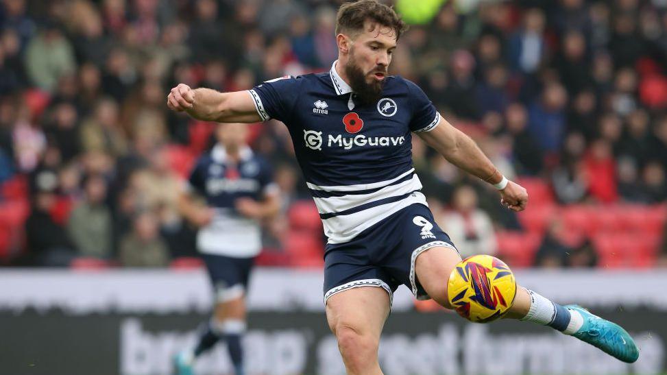 Tom Bradshaw strikes the ball while playing for Millwall