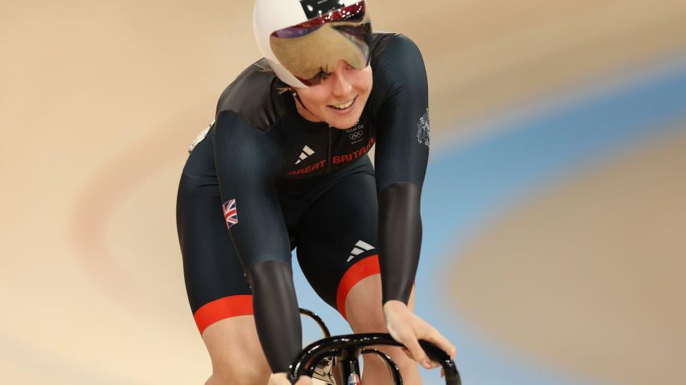 Emma Finucane smiling on a bike in the velodrome in Paris