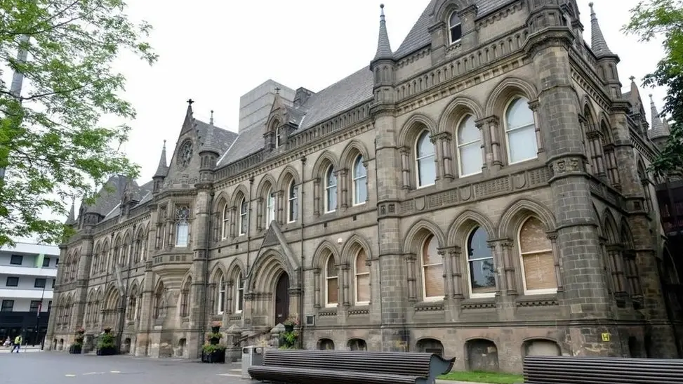 Large gothic town hall building with triangular archways and several windows.