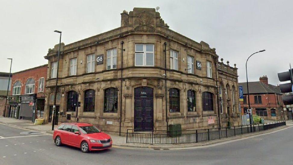 The outside of the building where Zambezi Lounge, in Attercliffe Road, in Sheffield is located, with black doors and windows, as well as light grey stone