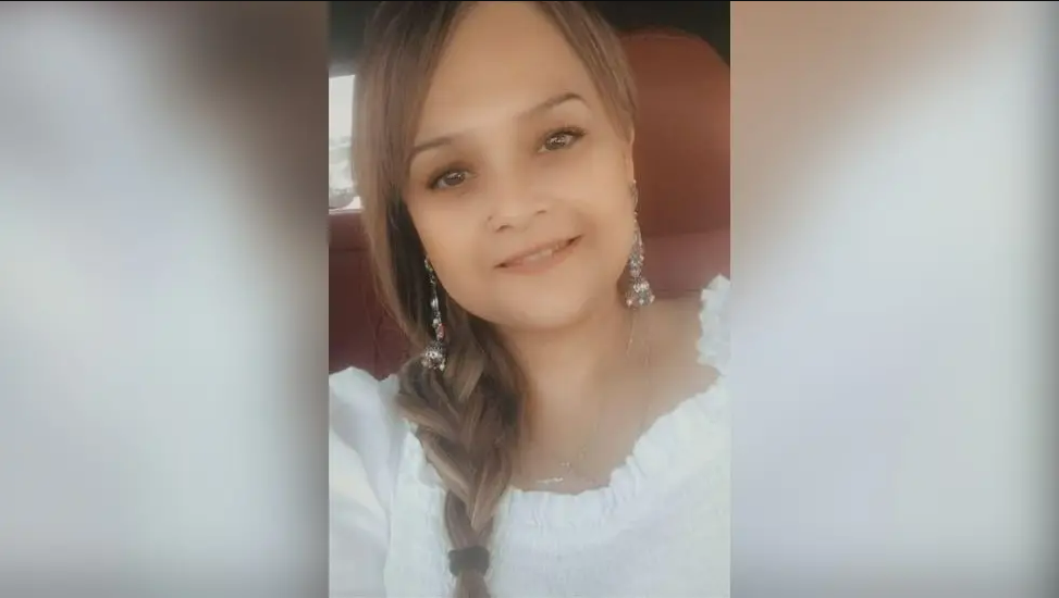 A selfie of Tarneet Riaz, smiling and wearing a white top with a plait in her hair 