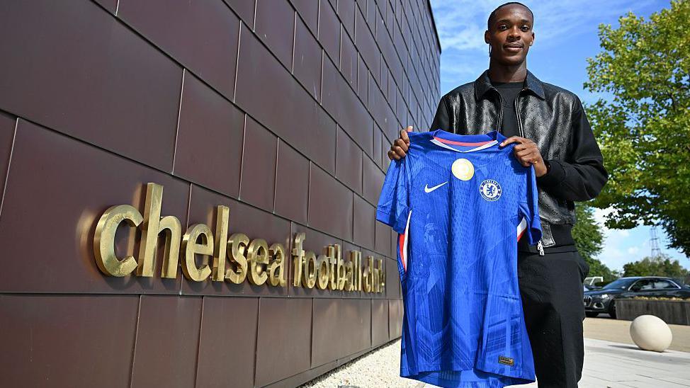 Strasbourg striker Emmanuel Emegha with a Chelsea shirt 