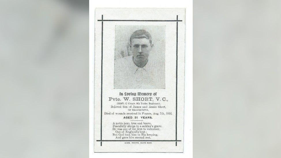 A memorial car to William Short with a black and white photogrpaph of him. He has a serious expression and short hair. The text on the card say he died at the age of 31 on 7 August 1916. It describes him as a "noble hero".