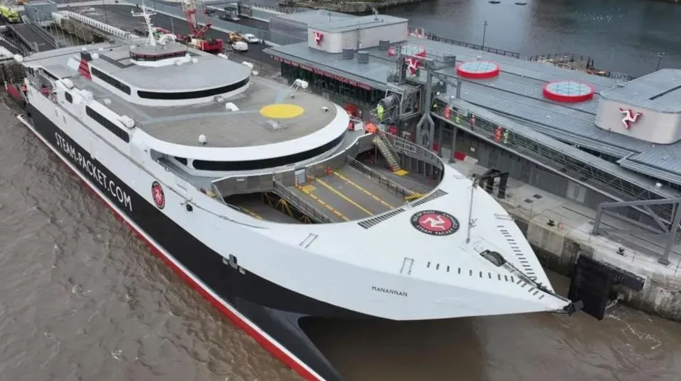 The Manannan docked at the new ferry terminal in Liverpool. The vessel is in the Steam Packet colours of white, red and black and it has the logo on the top of it's stern. The three-legs-of-Mann symbol can be seen on the terminal buildings.