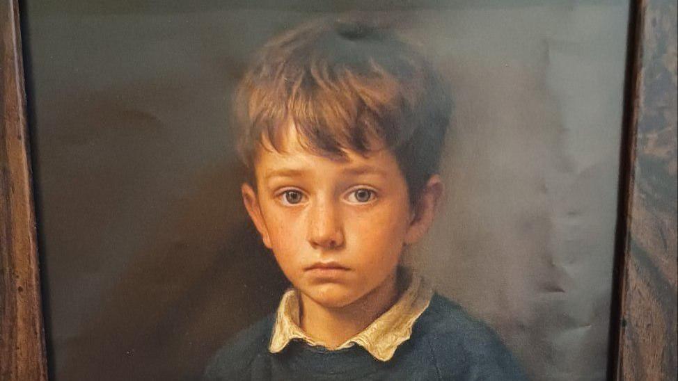 A close up of the school boy's face from the digital print. 