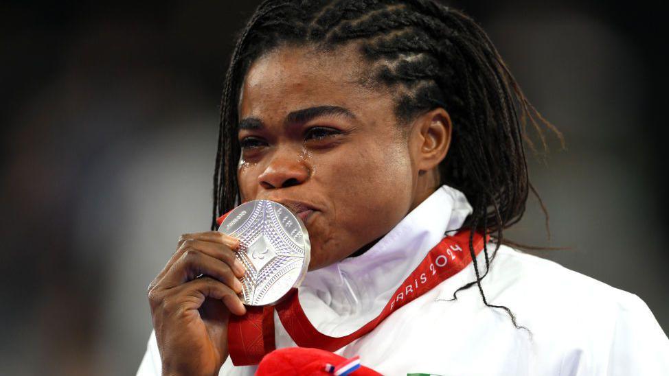 Esther Nworgu kisses her silver medal on the podium at the Paris 2024 Paralympic Games