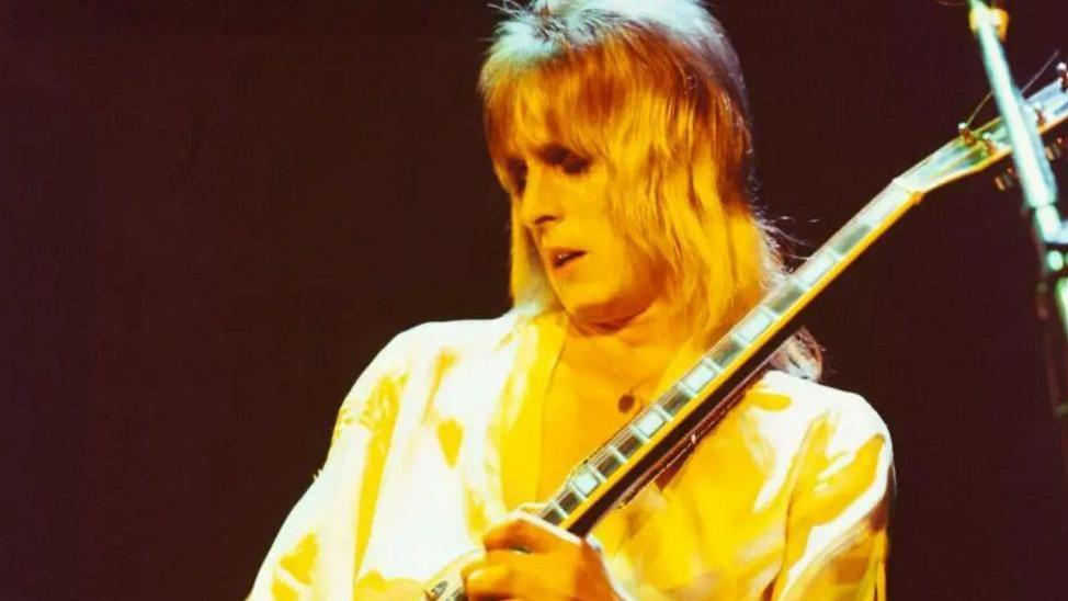 Mick Ronson playing a guitar