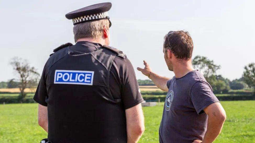 A farmer talking to a police officer