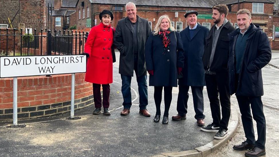 Family and friends next to the David Longhurst Way street sign, including his sisters Jayne (far left) and Ann (third from left), as well as his best friend John Salisbury (in between Jayne and Ann) 